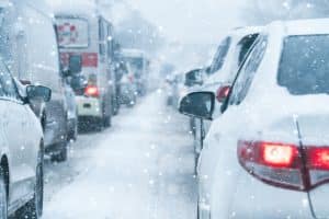 Traffic jam on a snow cowered road in winter time. A lot of snow cowered cars in a row.