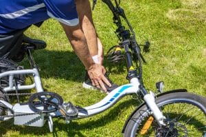 Cyclist with a broken leg and sprained ankle after an electric bike accident, the accident area is fenced with red and white tape, rescue operation after a cyclist's collision