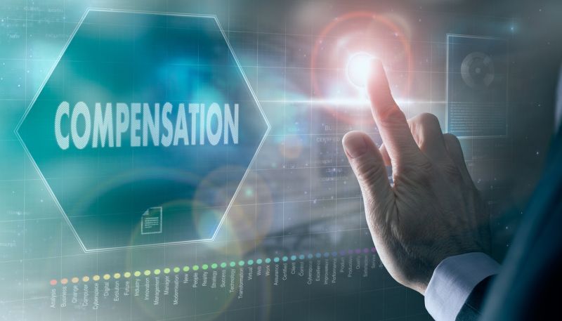 A businessman controlling a futuristic display with a Compensation concept on it.